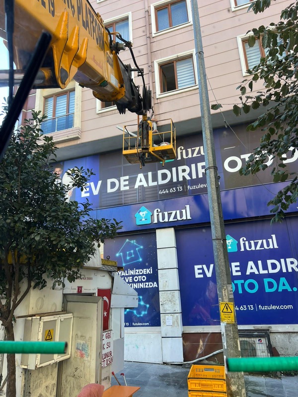 Bir mağaza cephesinde, tabela hizasında çalışan sepet